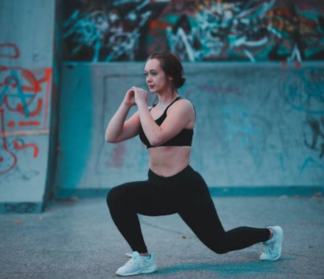 Woman performing a lunge exercise outdoors.