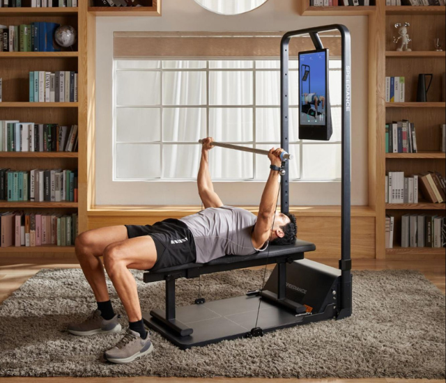 Man performing a barbell bench press with Speediance Gym monster 2