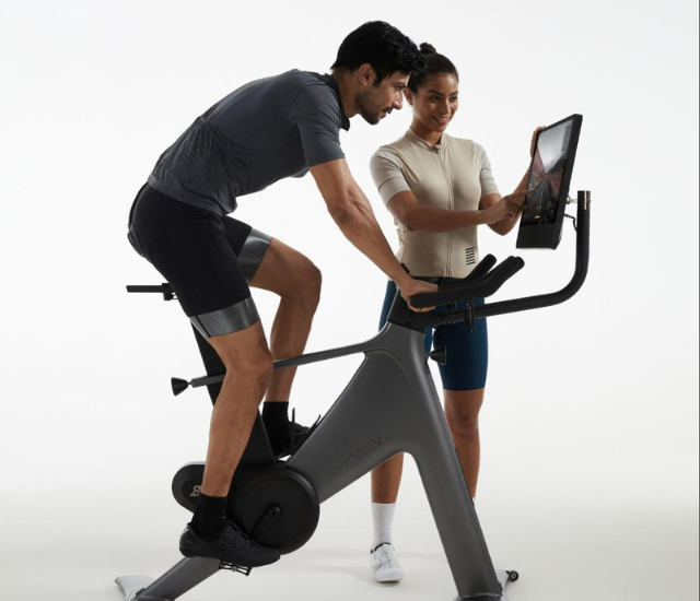 Individual uses VeloNix stationary bike with another individual