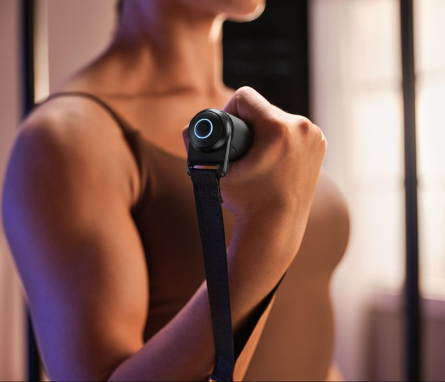 Closeup of woman's hand and arm holding cable machine handle
