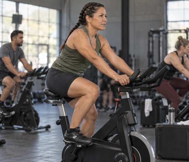 Woman pedaling an indoor bike during fitness race endurance training