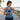Runner wearing a screen-free wrist tracker and holding a phone beside an outdoor path