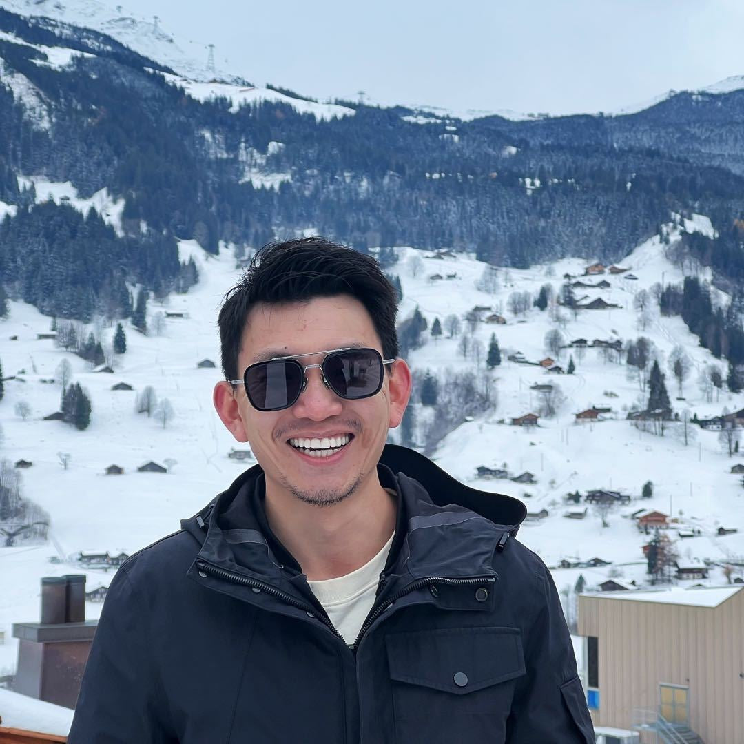 Man wearing sunglasses with a snowy mountain landscape in the background