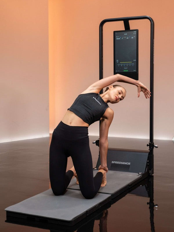 Person using Pilates reformer with digital display in studio
