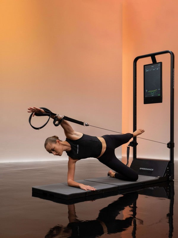 Woman using Pilates reformer in studio