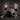 Four people posing with a fitness device against a dark wall.