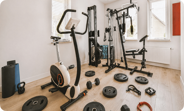 Home gym with exercise equipment on a wooden floor