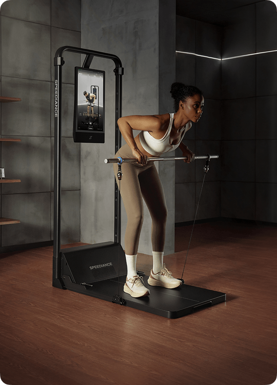 Woman exercising on a fitness machine in a dimly lit room.