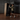 Person using a vacuum cleaner on a large cardboard box in a room with gray walls.